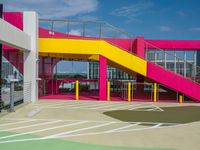 an empty parking lot with brightly painted stairs leading to a large open area for pedestrians to walk by