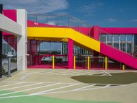 an empty parking lot with brightly painted stairs leading to a large open area for pedestrians to walk by