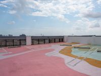 a large concrete parking lot on top of a building that has a colorful design on the floor