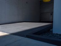 a gray walkway leading up to a building next to a yellow light lantern on top