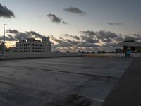 an empty parking lot with buildings in the background under a cloudy sky at dusk in florida