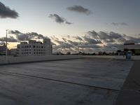 an empty parking lot with buildings in the background under a cloudy sky at dusk in florida