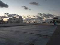 an empty parking lot with buildings in the background under a cloudy sky at dusk in florida