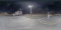 an empty city street with an umbrella on top of the roof at night time with light posts