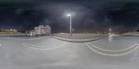 an empty city street with an umbrella on top of the roof at night time with light posts