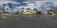 a wide view of a deserted street with some cars driving in front of it,