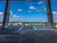 an empty parking space with the sky in the background and a view from inside the building