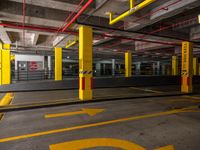 empty parking garage with arrow painted on the ground and yellow pips indicating how to use it