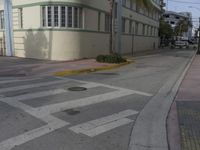 a city intersection with a street sign and a palm tree in the middle of the street