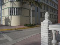 a city intersection with a street sign and a palm tree in the middle of the street