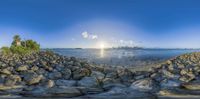 a 360 - view photo of the beach and a lake and buildings in the background