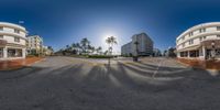 three buildings along the beach road with a car in front of them and a sunny sky