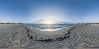 the view from inside a fish eye lens of the ocean in the distance, as people are walking along the shoreline