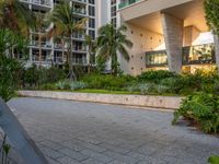 a park bench in front of a high rise building at twilight with trees and plants surrounding it