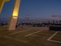 an outside view of a city skyline and a clock at sunset with lights on a pole