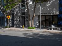 an intersection in the middle of a street next to buildings and trees with a sign that says,