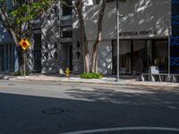 an intersection in the middle of a street next to buildings and trees with a sign that says,