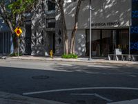 an intersection in the middle of a street next to buildings and trees with a sign that says,