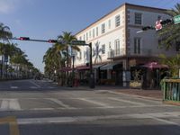 an empty intersection on a street with palm trees in the background on a sunny day