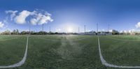 a 360 - shot view of an indoor field with many lights and the sun setting over the goal line