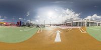 a sky view of an airport in the daytime and a road in the sun going through the middle