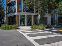 a zebra crossing on the street in front of a building with many different windows and plants