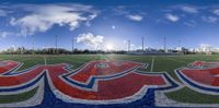 a fish eye lens view of a football field with a sky background and sun in the background