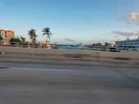 there is a person riding a motorcycle on the road at dusk in the city of miami