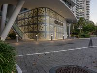 a large building surrounded by tall buildings near a manhole on a walkway in a city