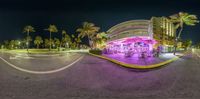 an upside down fish eye shot shows the restaurant, palm trees, and beach lights