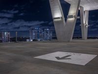 a parking sign pointing to the direction of an exit with buildings in the background and clouds in the sky