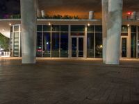 a tall pole is by a building at night with a sky background and bright lights on