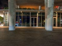 a tall pole is by a building at night with a sky background and bright lights on