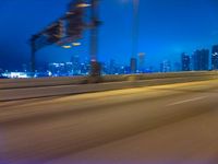 a blurry photo shows the city as the train is passing by at night near a light