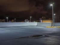 the parking lot is empty during the night with city lights on it's roofs