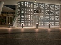 the word home stands out against a decorative wall at night in front of a shopping center