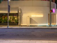 a street corner with a fire hydrant sitting next to it and a neon sign saying the entrance to a mall