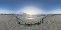 a panoramic photo of a beach and ocean at sunset with people walking on the sandy sand