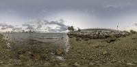 a panorama view of the shoreline of a harbor with a bridge in the distance and the building to the left of it