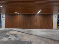 a parking garage with brown slatt and a light on the wall next to it