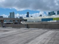 a view from across a empty parking lot at a city skyline with lots of tall buildings