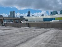 a view from across a empty parking lot at a city skyline with lots of tall buildings