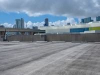 a view from across a empty parking lot at a city skyline with lots of tall buildings