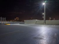 empty parking lot with building lights behind it at night time in urban setting at dusk