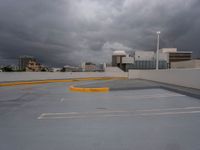 parking spaces on the rooftop of the building under a cloudy sky and clouds in the background