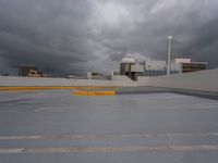 parking spaces on the rooftop of the building under a cloudy sky and clouds in the background