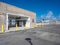 a parking lot is covered by yellow post caps and poles, with a bright blue sky in the background