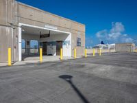 a parking lot is covered by yellow post caps and poles, with a bright blue sky in the background