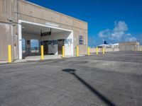 a parking lot is covered by yellow post caps and poles, with a bright blue sky in the background