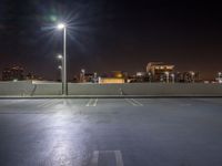 empty parking lot with city lights over the city skyline in the background at night time